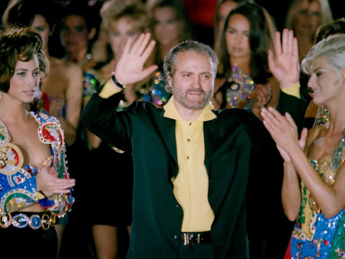 GIANNI SURROUNDED BY CELEBRITIES AND MODELS FOR VERSACE.